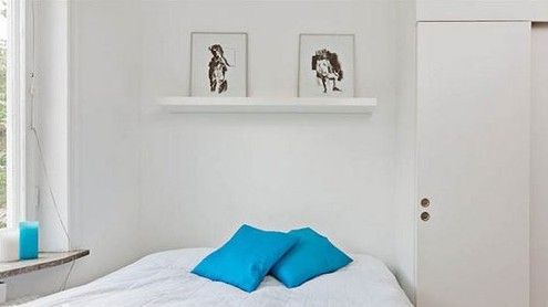 浅木色的地面搭配蓝白色的靠包床品，让整个卧室宁静中又多了几分亲和力